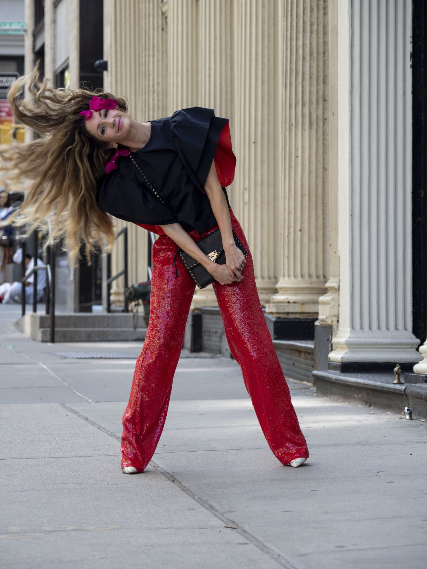 red sequin pants styled with black ruffle sleeve top